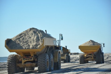 In addition to waterborne vessels, trucks are part of the process too. In this case they were hauling sand excavated as part of the habitat improvement work, then used toward dune and berm construction. (Photo courtesy United States Army Corps of Engineers, January 2015.)