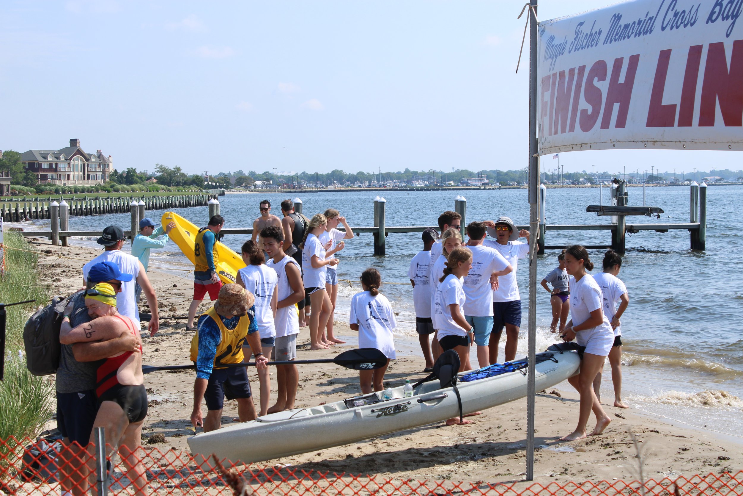Volunteers, swimmers and supporters gather at the finish line.
