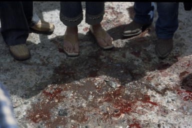 blood on the street between the legs of people